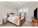 Cozy bedroom with hardwood floors, a wooden-frame bed, neutral walls, and natural light at 3618 Marchers Trace Dr, Mint Hill, NC 28227