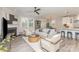 Open-concept living room with neutral decor, fireplace, ceiling fan, and seamless flow to dining and kitchen at 3618 Marchers Trace Dr, Mint Hill, NC 28227