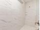Close-up of a shower featuring large white marble-style tiles, built-in bench, and sleek hardware at 3618 Marchers Trace Dr, Mint Hill, NC 28227