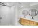 This modern bathroom offers double sinks, sleek tiling in the walk-in shower, and neutral walls and floors at 3619 Bankston Pl, Charlotte, NC 28215