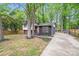 View of the exterior elevation with a black brick, white siding, pink door, large yard, and mature shade trees at 3619 Bankston Pl, Charlotte, NC 28215