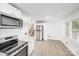 Bright kitchen featuring stainless steel appliances, bright white cabinets, and hardwood floors at 3619 Bankston Pl, Charlotte, NC 28215