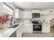 Bright kitchen featuring white cabinets, stainless steel appliances, and stone countertops at 3619 Bankston Pl, Charlotte, NC 28215