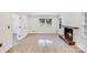 Bright living room features a brick fireplace, white brick wall and new wood flooring at 3619 Bankston Pl, Charlotte, NC 28215