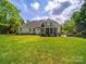 Expansive backyard featuring a lush lawn and a charming patio area with outdoor seating and a hot tub at 3700 Carolina Cherry Ct, Gastonia, NC 28056