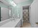 Bright bathroom features a dual vanity, large mirror, updated lighting, and a shower and toilet behind closed door at 3700 Carolina Cherry Ct, Gastonia, NC 28056