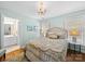 Well-lit bedroom showcases two side tables, elegant chandelier, two windows allowing natural light, and ensuite bathroom at 3700 Carolina Cherry Ct, Gastonia, NC 28056