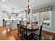 Open dining area with views of the kitchen, backyard access, and a decorative chandelier at 3700 Carolina Cherry Ct, Gastonia, NC 28056