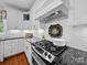 Modern gas cooktop set into dark countertops with white cabinetry and accent lighting at 3700 Carolina Cherry Ct, Gastonia, NC 28056