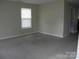 Cozy living room with neutral walls, plush carpeting, and a bright window at 391 Morning Dew Dr, Concord, NC 28025