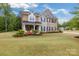Charming two-story home with brick and stone exterior, landscaped yard and covered front porch with chairs at 4008 Pinot Way, Fort Mill, SC 29707