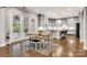 Open kitchen featuring gray cabinets, stainless appliances, island seating, and adjacent dining area at 4008 Pinot Way, Fort Mill, SC 29707