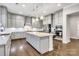Kitchen with a granite island, gray cabinets, hardwood floors, tile backsplash, and stainless steel appliances at 4008 Pinot Way, Fort Mill, SC 29707