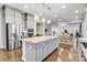 Open kitchen featuring large island, stainless steel appliances, gray cabinets, and hardwood floors at 4008 Pinot Way, Fort Mill, SC 29707