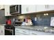 Modern kitchen features granite countertops, stainless steel appliances, and a gray backsplash at 4204 Steel Way, Sherrills Ford, NC 28673