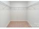 Empty walk-in closet featuring shelving and carpet flooring, providing ample storage space at 4208 Steel Way, Sherrills Ford, NC 28673