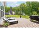 Relaxing back deck with lounge chairs, a grill, and view of the manicured lawn and wooded area at 500 Chicory Cir, Matthews, NC 28104