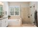 Bright bathroom featuring a large window, soaking tub, and a separate shower with glass door at 500 Chicory Cir, Matthews, NC 28104