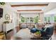 Bright, inviting living room featuring hardwood floors, wooden beams, a large sectional sofa, and backyard view at 500 Chicory Cir, Matthews, NC 28104