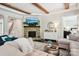 Cozy living room with hardwood floors, a stone fireplace, exposed beams, comfortable seating, and lots of natural light at 500 Chicory Cir, Matthews, NC 28104