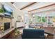 Elegant living room with a stone fireplace, hardwood floors, stylish furnishings, and a light-filled view to outside at 500 Chicory Cir, Matthews, NC 28104