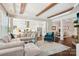 Open-concept living room with hardwood floors, wooden beams, and view of kitchen and dining area at 500 Chicory Cir, Matthews, NC 28104
