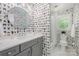 Charming bathroom with vanity, round mirror, and unique dog-themed wallpaper throughout at 5206 Morrowick Rd, Charlotte, NC 28226