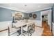 Dining room showcasing modern art, a gray wash table, hardwood floors, and contemporary chairs at 5206 Morrowick Rd, Charlotte, NC 28226