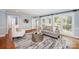 Cozy living room featuring a comfortable sofa, bright windows, neutral walls, and hardwood floors at 5206 Morrowick Rd, Charlotte, NC 28226