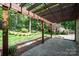 A covered pergola with a view of a lush backyard and mature trees at 5206 Morrowick Rd, Charlotte, NC 28226