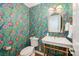 Charming powder room is adorned with vibrant floral wallpaper, brass fixtures, and an eye-catching mirror at 5206 Morrowick Rd, Charlotte, NC 28226