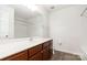 Bathroom features a single sink vanity with wood cabinets, a large mirror, and tub at 5310 Waverly Lynn Ln, Charlotte, NC 28269