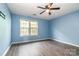 Cozy bedroom with light blue walls, natural light from the window, and a ceiling fan at 5310 Waverly Lynn Ln, Charlotte, NC 28269