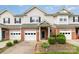 Inviting townhome with brick accents, white siding, manicured landscaping, and attached garages at 5310 Waverly Lynn Ln, Charlotte, NC 28269