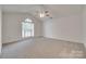 Bright bedroom featuring a ceiling fan, neutral carpet, and a large arched window at 605 Summey Farm Dr, Dallas, NC 28034