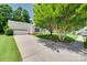 View of the home showcasing the driveway leading to the attached garage and a lush green lawn at 605 Summey Farm Dr, Dallas, NC 28034
