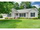 Charming single-story home featuring a well-manicured lawn, lush landscaping, and a classic white exterior at 605 Summey Farm Dr, Dallas, NC 28034