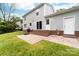 Backyard featuring a brick patio, sliding glass doors, and lush green grass, perfect for outdoor living at 616 Silversmith Ln, Charlotte, NC 28270