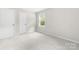 Bright bedroom with neutral carpet, a window with blinds, and two white doors at 616 Silversmith Ln, Charlotte, NC 28270