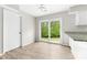 Bright dining area featuring wood-look floors, a sliding glass door, and white cabinets at 616 Silversmith Ln, Charlotte, NC 28270