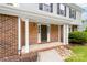 Inviting front porch with brick columns, a stylish front door, and manicured landscaping around the entrance at 616 Silversmith Ln, Charlotte, NC 28270