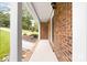 Covered front porch with brick support columns, offering a glimpse of the landscaped yard and charming facade at 616 Silversmith Ln, Charlotte, NC 28270