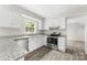 Bright kitchen with white cabinets, granite countertops, stainless steel appliances, and modern flooring at 616 Silversmith Ln, Charlotte, NC 28270