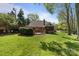 Expansive backyard boasts lush green grass, mature trees, and a cozy patio area at 6202 Providence Country Club Dr, Charlotte, NC 28277
