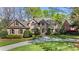 Elegant brick home featuring manicured landscaping, a circular driveway, and mature trees under a bright blue sky at 6202 Providence Country Club Dr, Charlotte, NC 28277