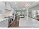 Well-lit kitchen with marble countertops, stainless steel appliances, and adjacent dining and living areas at 6202 Providence Country Club Dr, Charlotte, NC 28277