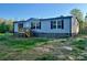 Charming single-story home featuring light blue siding, black shutters, and a wooden porch at 796 Old Wilkesboro Rd, Taylorsville, NC 28681