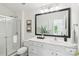 Well-lit bathroom with a glass-enclosed shower, vanity, and decorative mirror at 9027 Mcdowell Creek Ln, Cornelius, NC 28031