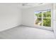 A sunlit, spacious bedroom featuring a large window with a view of the surrounding landscape at 9027 Mcdowell Creek Ln, Cornelius, NC 28031