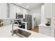 Modern kitchen with stainless steel appliances, white cabinetry, and a view into the laundry room at 9027 Mcdowell Creek Ln, Cornelius, NC 28031